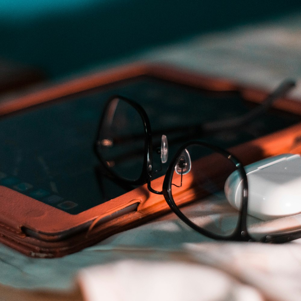 Glasses resting on a tablet beside a soft cloth